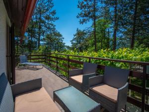 a balcony with chairs and tables and trees at Chalet Nina by Interhome in Lič