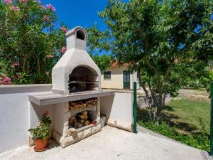 um forno de pizza sentado ao lado de uma casa em Holiday Home Domy by Interhome em Rab
