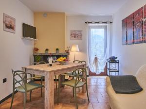 salon z drewnianym stołem i krzesłami w obiekcie Apartment Locanda del Nibbio-2 by Interhome w mieście Carriola