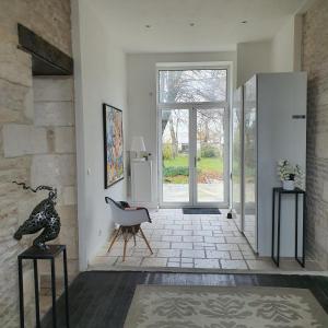 a living room with a sliding glass door and a chair at Maison Laurenza/ La Liversoise in Saint-Jean-de-Liversay