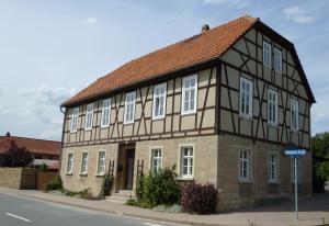 un edificio con techo marrón y ventanas blancas en FeWo Gutendorf en Bad Berka