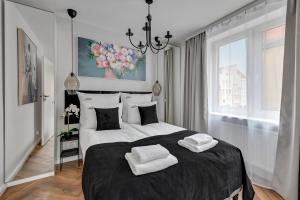 a bedroom with a large bed with two towels on it at Downtown Apartments Magical River View in Gdańsk