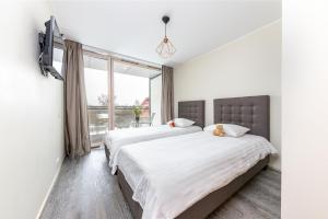 - une chambre avec 2 lits et une fenêtre dans l'établissement Aisa 39 Apartments, à Pärnu