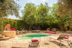 a backyard with a pool with chairs and a table at Masseria Li Reni in Manduria