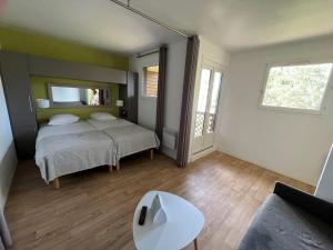 - une chambre avec un lit, une table et un canapé dans l'établissement Villages Clubs du Soleil - SOUSTONS - Locatif, à Soustons