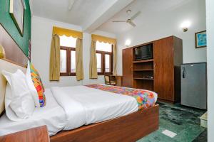 um quarto com uma cama grande e uma televisão em FabExpress Primero I em Gurgaon