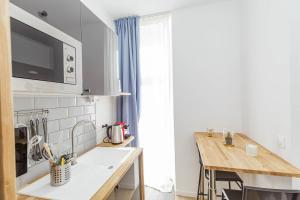 una pequeña cocina con encimera y mesa en Nice 23 M Bright And Renovated Courtyard Side, en París