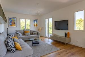 uma sala de estar com um sofá e uma televisão de ecrã plano em Pyla Plage - appartement vue mer - Perle(o) em La Teste-de-Buch