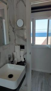 baño con lavabo, espejo y ventana en Apartamento en primera línea de mar, las Teresitas, Santa Cruz de Tenerife, en San Andrés