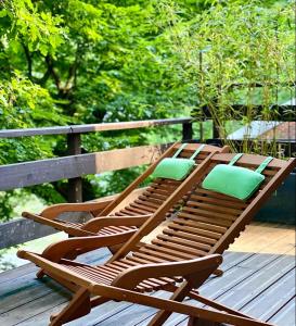 a wooden lounge chair with green pillows on a wooden deck at COCOONING near DINANT 300m from River Meuse in Blaimont