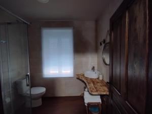 a bathroom with a sink and a toilet and a window at CASA RURAL VEGASAN in Santa Colomba de la Vega