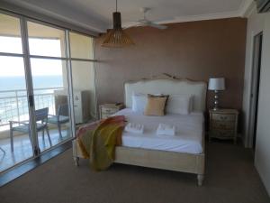 a bedroom with a white bed and a balcony at 2nd Avenue Beachside Apartments in Gold Coast