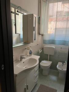 a bathroom with a sink and a toilet and a window at La casa di Ladì in Scilla