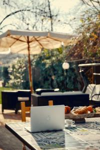 a laptop computer sitting on a table with an umbrella at Casa Consalvo in Pontecagnano