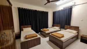 two beds in a room with black curtains at Rostel Backpackers Hostel in Pune