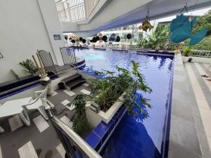 a large swimming pool with plants in a building at Lucky Suite Kandi 2 bedrooms in Angeles