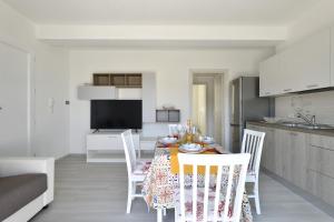 a kitchen and dining room with a table and chairs at Venere in Cala Gonone