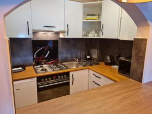 een keuken met witte kasten en een fornuis met oven bij Apartament Wyszyńskiego Szczecin Polska in Szczecin