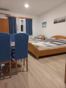 圖茲拉的住宿－Apartments Emir，一间设有两张床和蓝色椅子的房间