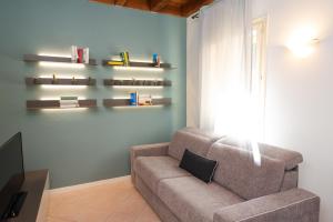 un soggiorno con divano e scaffali sul muro di Appartamento La Piazzetta a Carpi