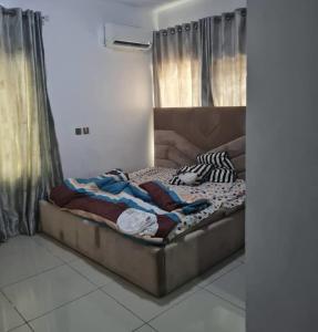 a large bed in a room with curtains at Plistbooking 3 Bedroom Duplex, City View Estate in Pakuro