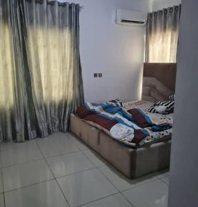 a bed sitting in a room next to a window at Plistbooking 3 Bedroom Duplex, City View Estate in Pakuro