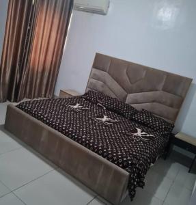 a bedroom with a bed with a brown head board at Plistbooking 3 Bedroom Duplex, City View Estate in Pakuro