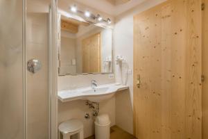 a bathroom with a sink and a mirror at Hotel Residence Gardena Saslong in Santa Cristina in Val Gardena +16 photos