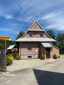 een roze gebouw met een dak op een straat bij Nocowanie w młynie in Niedzica