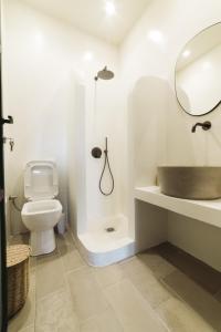 een badkamer met een toilet, een wastafel en een spiegel bij Yasemi in Argostoli