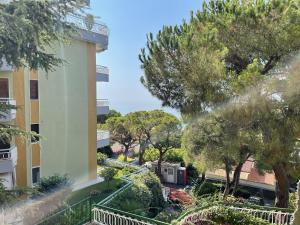 Blick auf ein Gebäude mit Bäumen und Sträuchern in der Unterkunft Suite Semeria 130 - Relax, Mare, Parking in Sanremo
