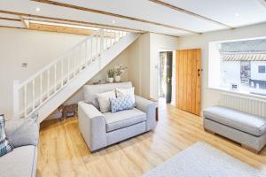 sala de estar con sofá, silla y escaleras en Host & Stay - Eden Cottage, en Holy Island