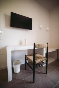 een tafel met een stoel en een televisie aan een muur bij Yasemi in Argostoli