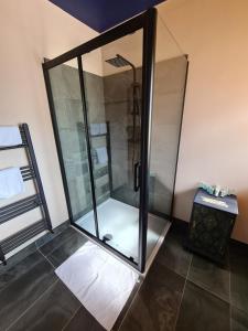 a shower with a glass door in a bathroom at Rumer Hill House a unique boutique styled place to stay in Cannock close to A5 the McArthur Glen outlet in Great Wyrley