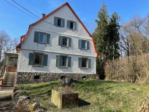 a large white house on top of a yard at Schellnhof Forsthaus am Waldrand in Nidda