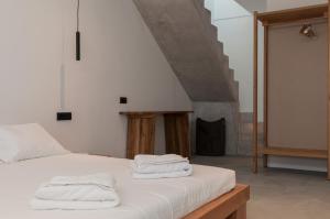 a bedroom with a bed with towels on it at Stremma Naxos in Aliko Beach