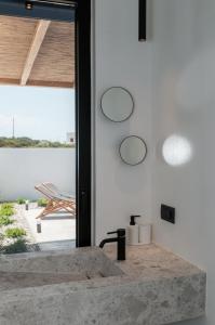 a bathroom with a stone sink in front of a window at Stremma Naxos in Aliko Beach
