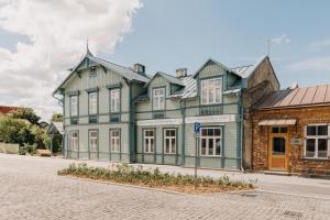 un grand bâtiment vert et blanc dans une rue dans l'établissement Villa Fannyhof, à Haapsalu