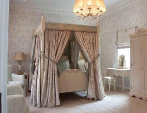 a bedroom with a canopy bed and a chandelier at St James Hotel; BW Premier Collection in Nottingham