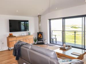 a living room with a couch and a fireplace at Sandpiper in Perranporth
