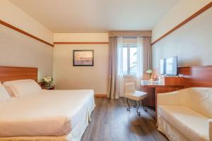 een hotelkamer met 2 bedden en een bureau bij SHG Hotel Bologna in Zola Predosa