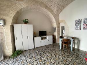 Cette chambre comprend une table et une armoire blanche. dans l'établissement Graziella Home, à Martina Franca