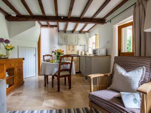 uma sala de estar com uma mesa e uma cozinha em Climbing Rose Cottage - Dog Friendly - Peaceful Cotswold Cottage em Adlestrop