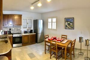 a kitchen with a table and a stainless steel refrigerator at Villa Artemis in Small Kounoupi Porto Heli in Porto Heli