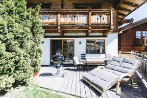 eine Terrasse mit einem Grill und einer Couch auf einer Terrasse in der Unterkunft Andis Almdorf in Sölden