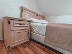 a bedroom with a bed and a wooden cabinet at Motel Almy in Zenica