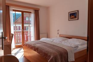 a bedroom with a bed and a large window at Luxury Apartments Bolf in Hočko Pohorje