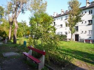 a red park bench in front of a building at Minigarzon in Budapest