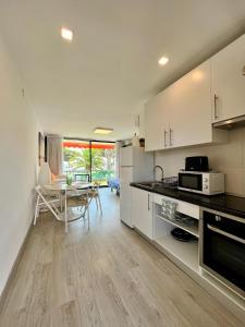 uma cozinha com armários brancos e uma sala de jantar em Residencia Beach em Cambrils