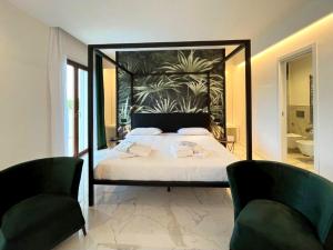 a bedroom with a large bed with two chairs at Hotel Alpha in Sant'Agnello